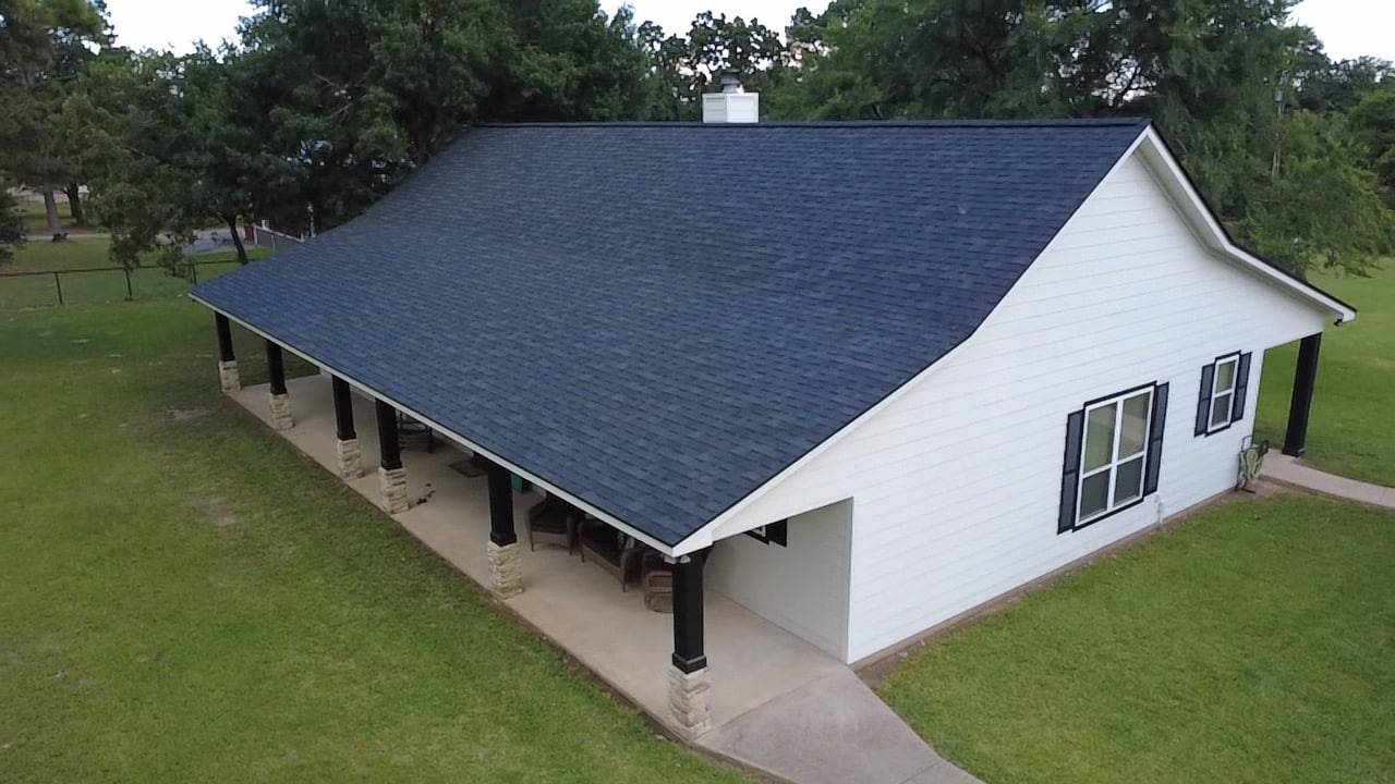 Home with a new dark shingle roof and covered front porch