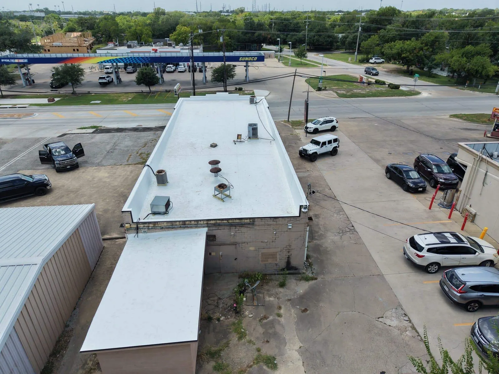 Aerial view of a commercial building with a white flat roof
