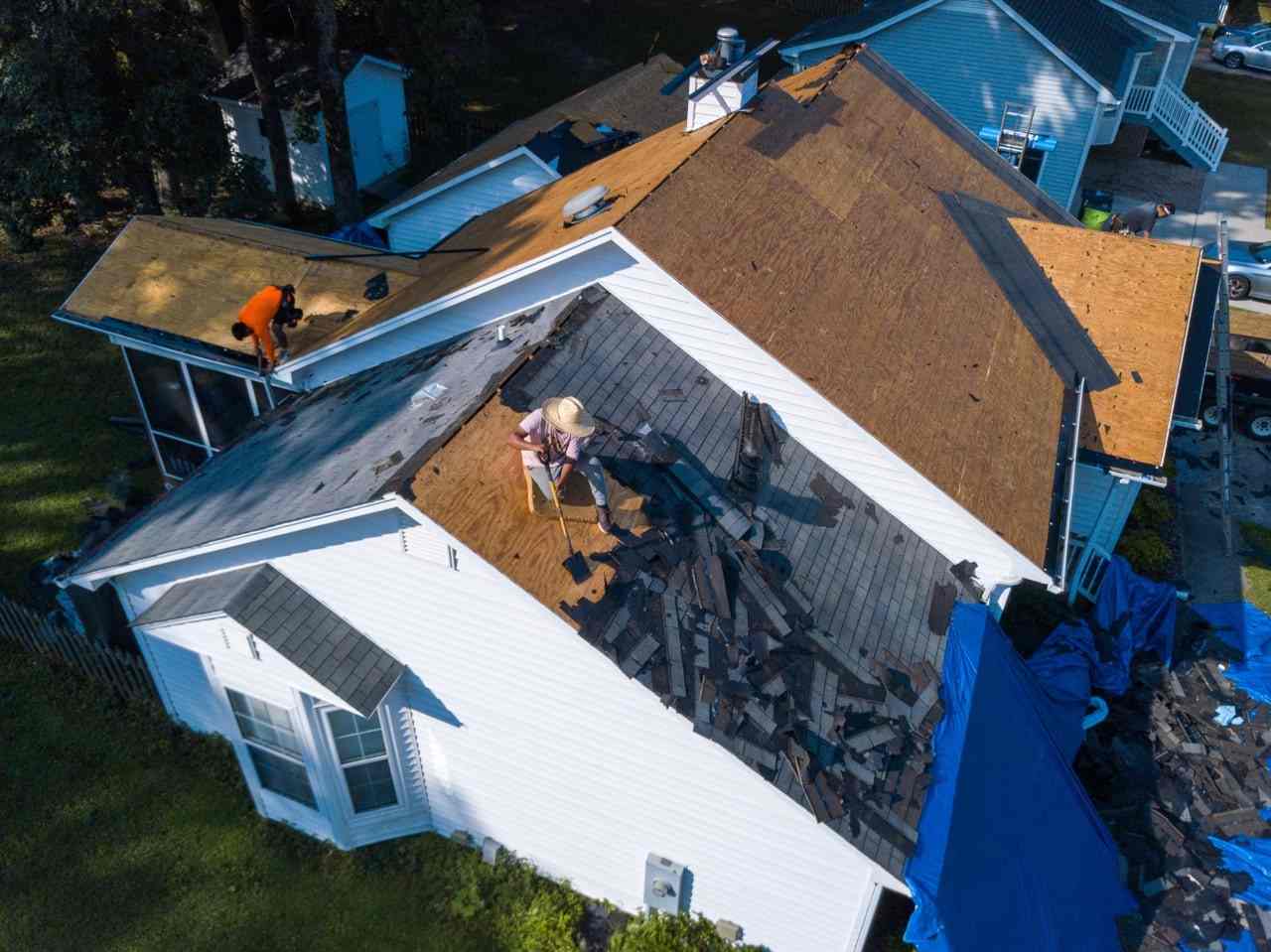 Crew replacing the roof on a home, aerial view