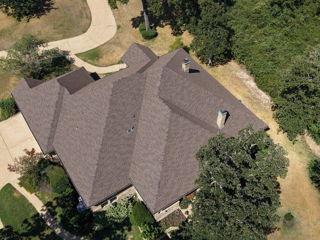 Aerial view of a large home with a new brown shingle roof