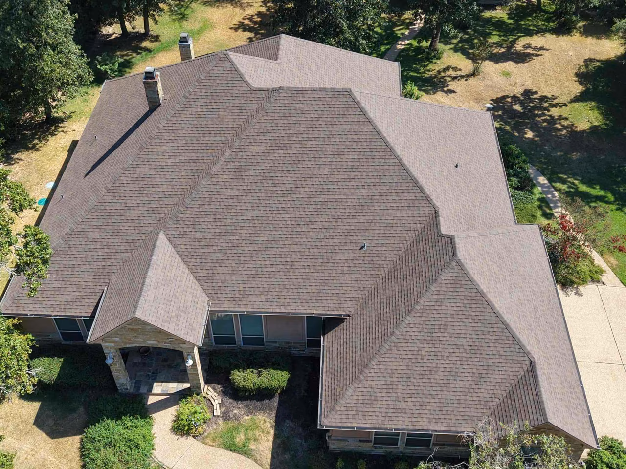 Aerial view of a multi-gable home with a new brown shingle roof