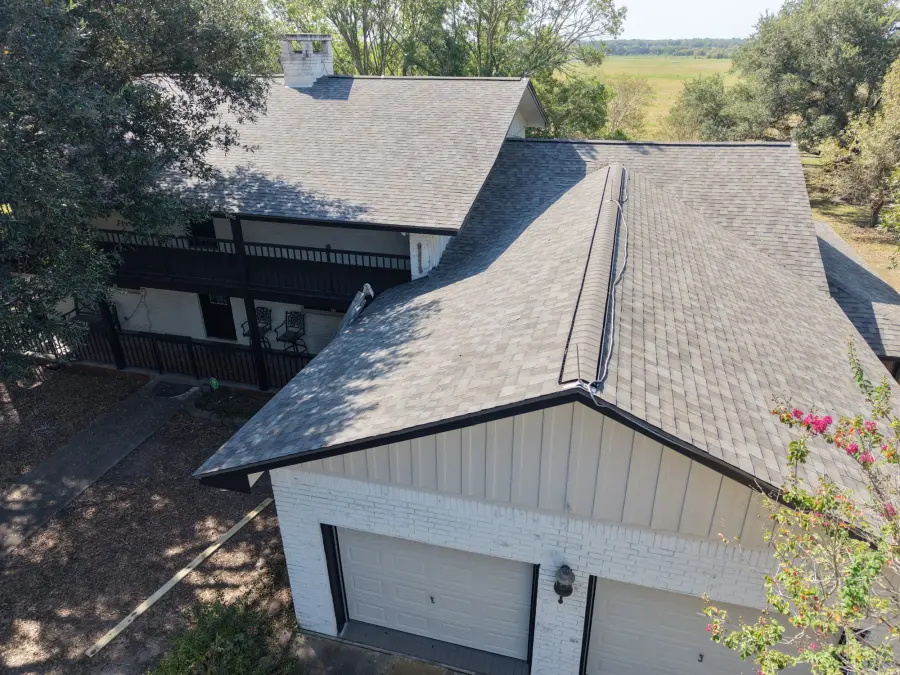 Aerial view of a gray shingle roof on a two story home with a garage