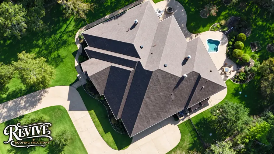 Aerial view of a large home with a new dark architectural shingle roof and a pool