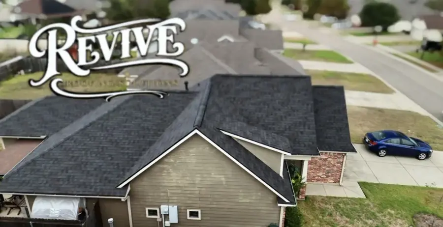 Low aerial view of a new dark shingle roof on a brick and siding home