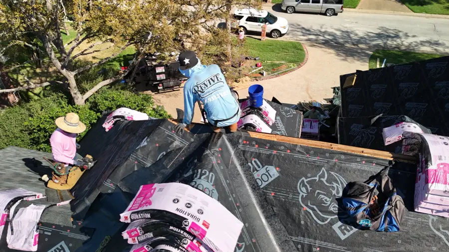 Revive crew members laying underlayment and shingles on a residential roof