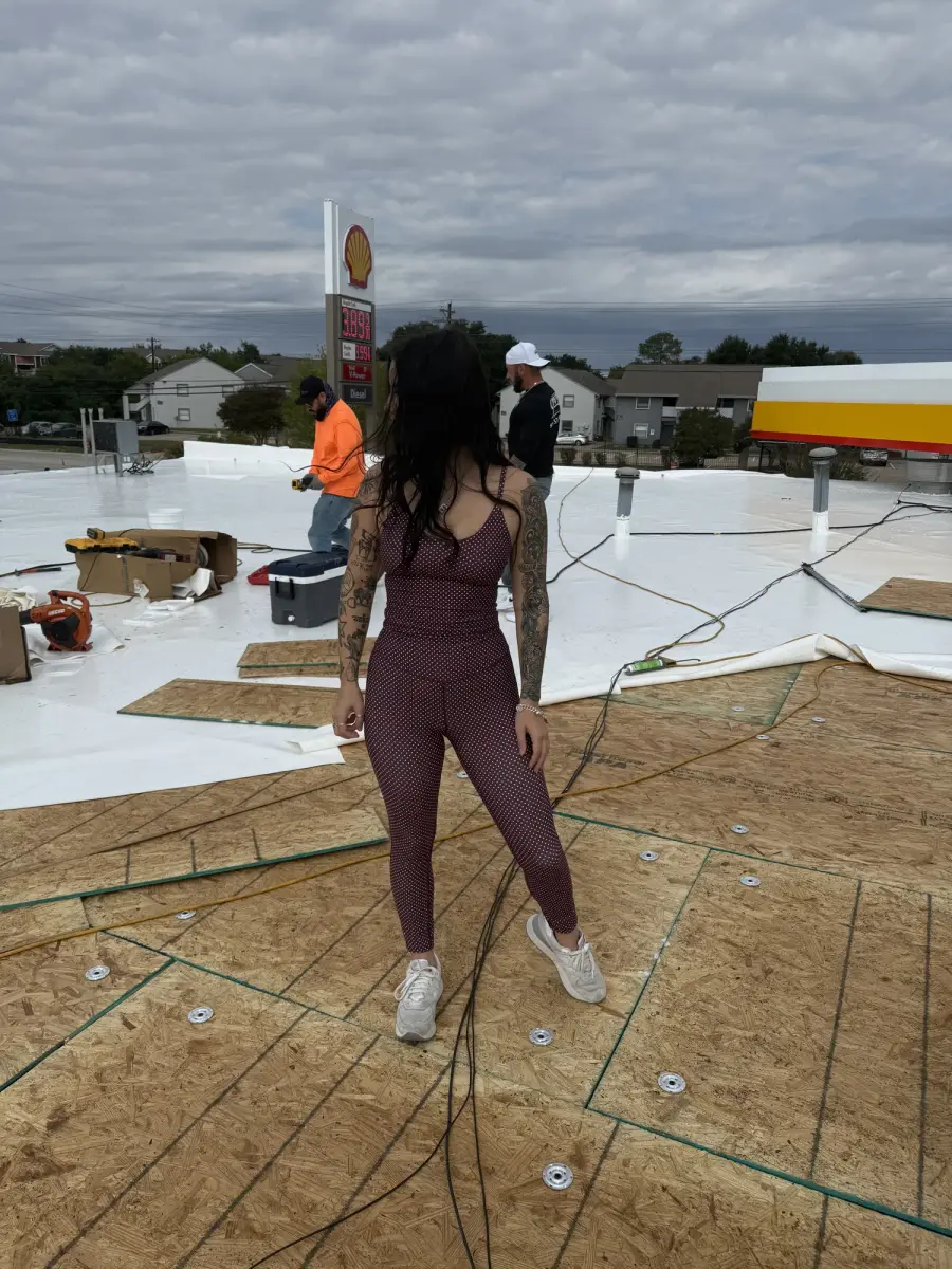 Roofer standing on a flat commercial roof during a membrane installation