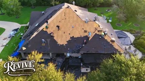 Aerial view of a roof tear off in progress on a large home
