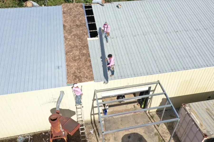 Revive crew members replacing sections of a commercial metal roof