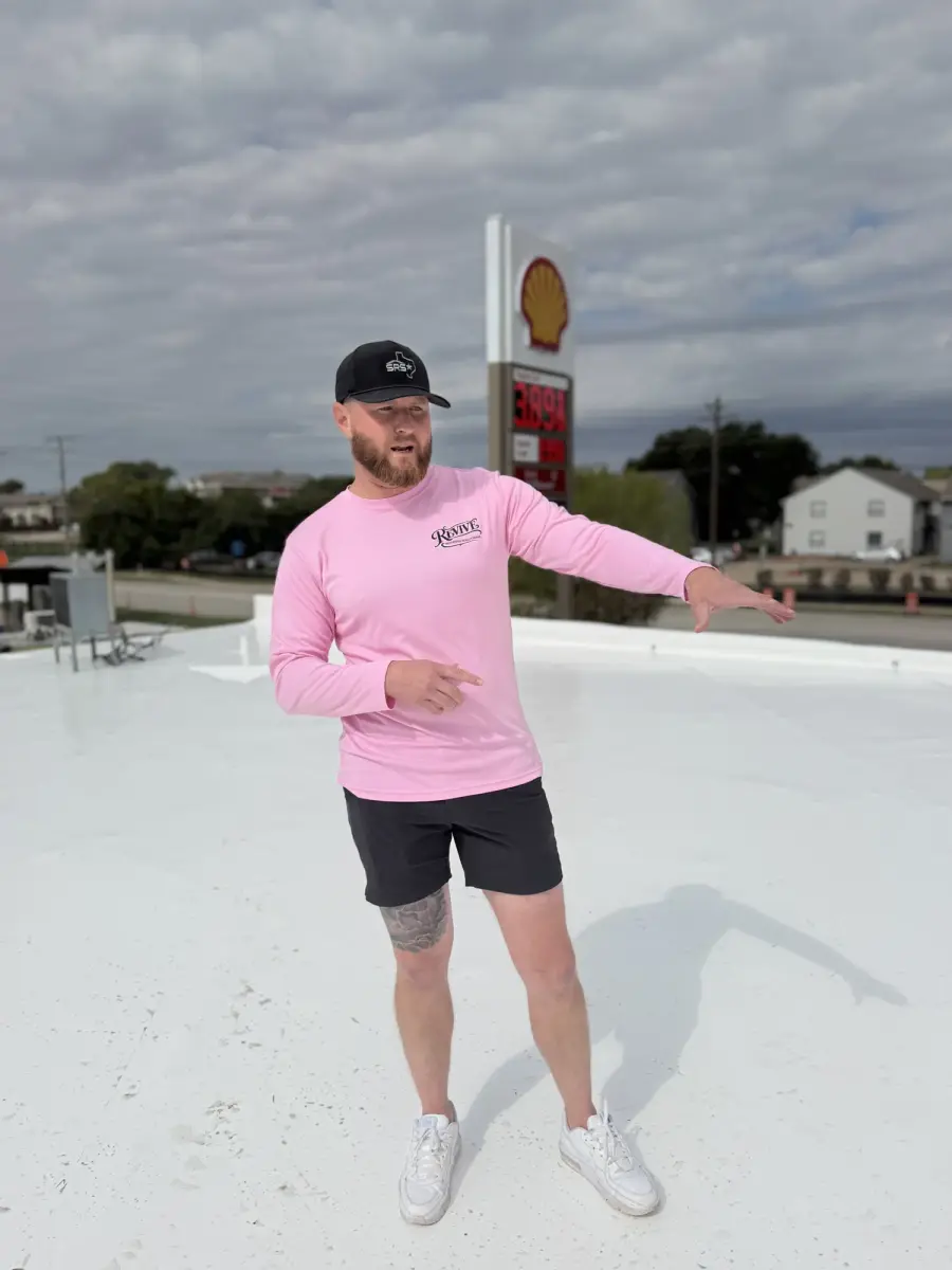 Revive team member standing on a newly finished white flat roof
